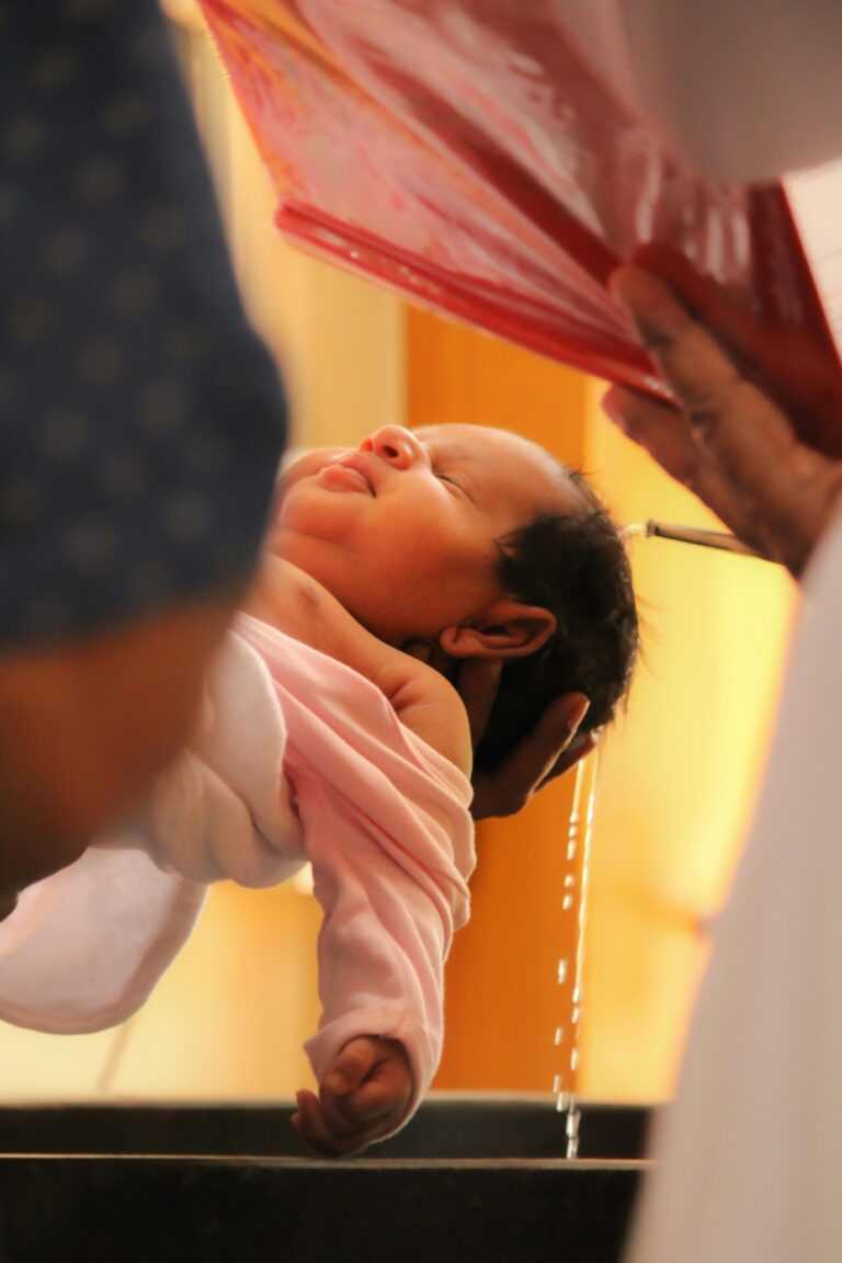 A serene moment of a baby being baptized in a church ceremony.